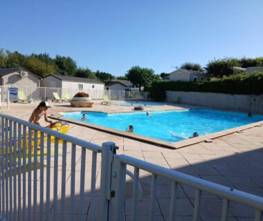Piscine extérieure avec baigneurs et mobil-homes au camping La terrasse du chat