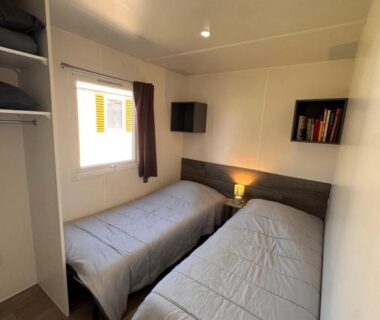 Chambre intérieure avec deux lits simples dans le mobil home Lac Des Rêves