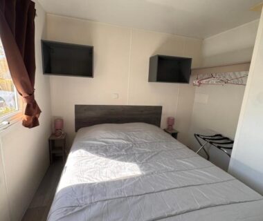 Intérieur chambre avec lit double et rangements dans le mobil home Lac Des Rêves