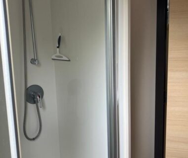 Cabine de douche avec pommeau et porte coulissante dans le Lagon B032
