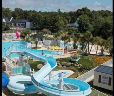Espace piscine extérieur avec toboggans et transats au camping Lambé