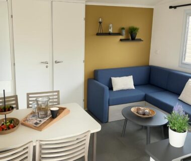 Séjour avec canapé d'angle et coin repas dans le logement Lambé