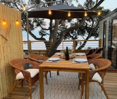 Terrasse en bois avec table et chaises au bord de l'eau à L'arbre perché