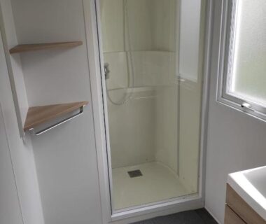 Salle d'eau avec cabine de douche et lavabo dans le 384 mobilhome Clim Velos TV lavlinge plancha transats