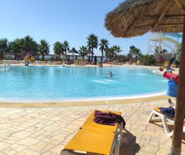 Piscine extérieure avec transats et parasols dans Le 384 mobilhome Clim Velos TV lavlinge plancha transats