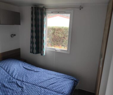 Chambre avec lit et fenêtre dans Le 384 mobilhome Clim Velos TV lavlinge plancha transats