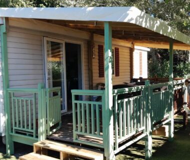 Mobil-home avec terrasse couverte sur pelouse au camping Le Bel' Azur