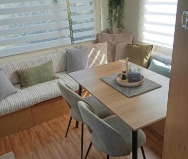 Intérieur avec coin repas et banquette dans le mobil-home Le Bruant des Roseaux