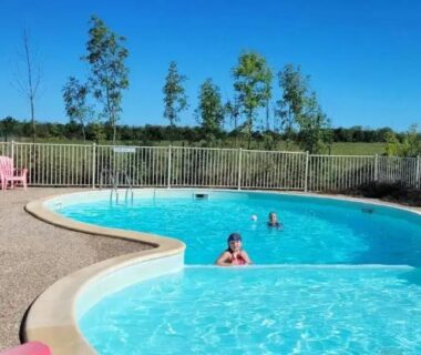 Piscine extérieure avec baigneurs au camping Le Bruant des Roseaux