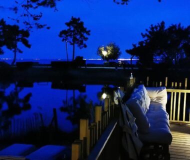 Terrasse de nuit avec banquettes et vue sur le bassin d'Arcachon au Bungalow du Ferret