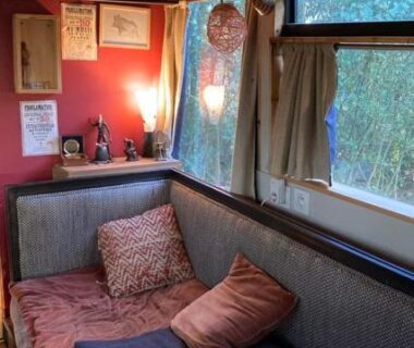 Intérieur cosy avec banquette et coussins dans Le Bus de la Forêt