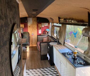 Intérieur du bus avec kitchenette et coin salon dans Le Bus de la Forêt