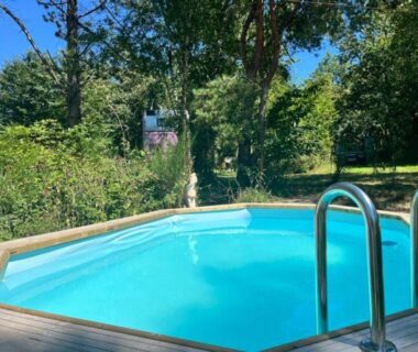 Piscine octogonale sur terrasse boisée au camping Le Bus de la Forêt