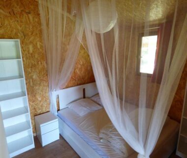 Chambre avec lit et moustiquaire du camping Le Carbet Vendéen