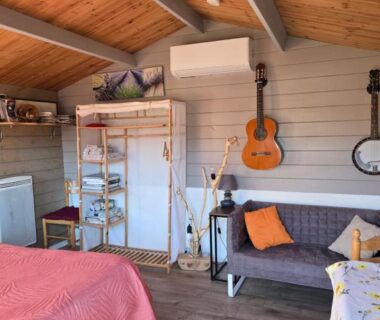 Chambre sous combles avec lit canapé et guitare dans le Chalet des Dany