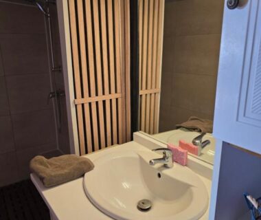 Salle de bain avec lavabo miroir et serviette dans le Chalet des Dany