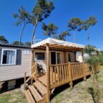 Terrasse en bois avec auvent et pins du mobil-home Le Chevreuil Vert