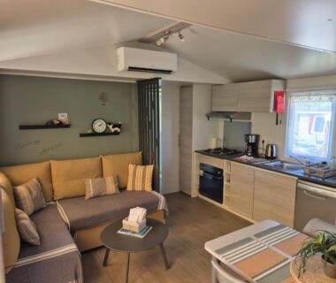 Séjour avec canapé et kitchenette dans le mobil-home Le Chevreuil Vert