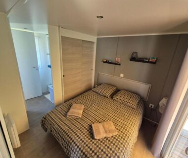 Chambre avec lit double et serviettes dans le logement Le Chevreuil Vert