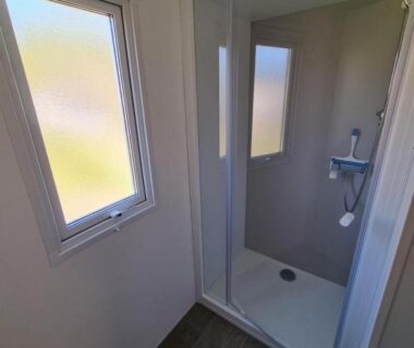Salle d'eau avec cabine de douche et fenêtre dans le Chevreuil Vert