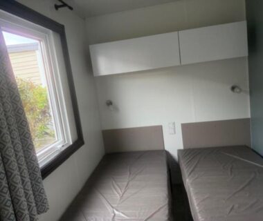 Intérieur de chambre avec deux lits simples au camping Le Clarys