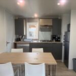Cuisine équipée avec table et chaises dans le mobil home du camping Le Clarys