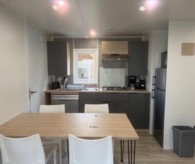 Cuisine équipée avec table et chaises dans le mobil home du camping Le Clarys