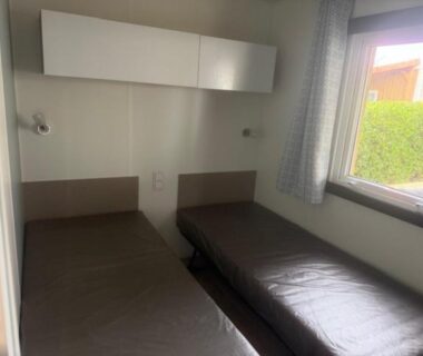 Chambre avec deux lits simples et fenêtre au camping Le Clarys