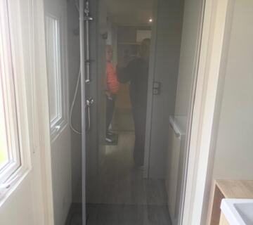 Couloir et cabine de douche vitrée dans le mobil-home Le Clarys