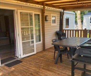 Terrasse couverte avec table chaises et barbecue du logement Le Cocon Landais
