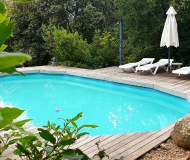 Bassin sur terrasse en bois avec transats et parasol au camping Le Cocon au fil de soi