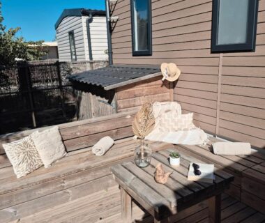 Terrasse en bois avec banquette et table du mobil home Le Cosy au Camping Les Dunes