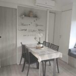 Intérieur mobil-home avec table et chaises et climatisation dans Le Cosy de Tess Mobil-home Sublima 6 personnes