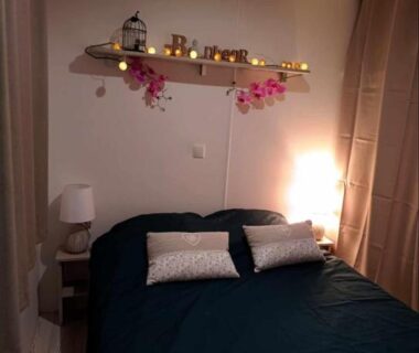 Chambre avec lit double, étagère lumineuse et lampes de chevet dans le mobil-home Le Cosy de Tess Sublima 6 personnes