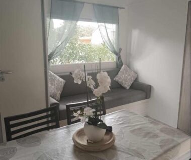 Espace repas avec banquette et table dans le mobil-home Le Cosy de Tess