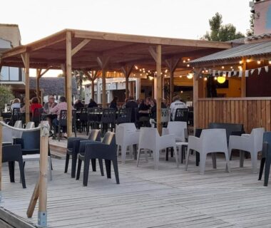 Terrasse extérieure avec tables et guirlandes au mobil-home Le Cosy