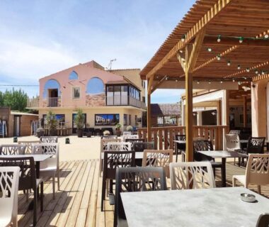 Terrasse en bois avec tables et guirlandes au mobil-home Le Cosy