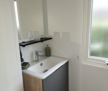 Salle d'eau avec lavabo et meuble dans le mobilhome Le Cozy'Land