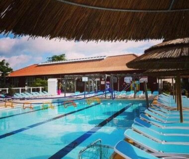 Piscine extérieure avec transats et paillotes au Cozy'Land Mobilhome Camping La Réserve