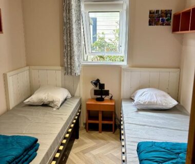 Chambre avec deux lits simples et fenêtre au Domaine des Pins