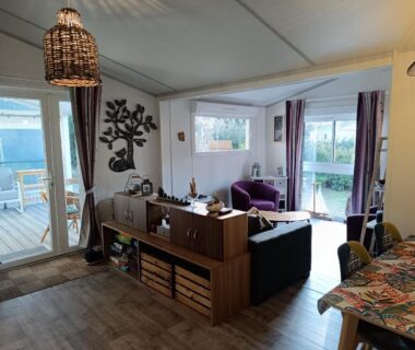 Salon avec baie vitrée donnant sur terrasse extérieure au Domaine des Pins