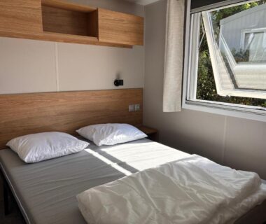 Chambre double avec fenêtre ouverte dans le mobil-home Le Domaine des Pins