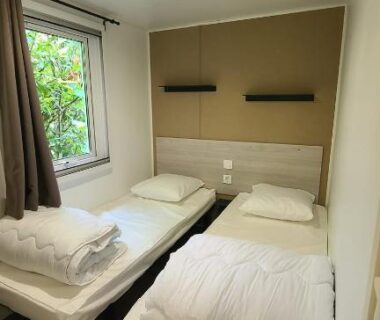 Chambre avec deux lits simples et fenêtre sur verdure au Domaine du Bois Coquet