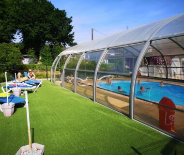 Piscine couverte avec transats et pelouse au Domaine du Scorff
