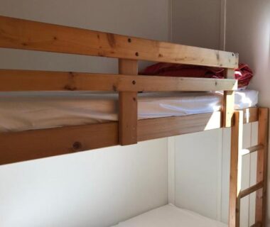 Chambre avec lits superposés et échelle dans le chalet au Domaine du Scorff