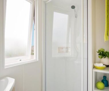 Salle d'eau avec douche vitrée et fenêtre au camping Le Goh Velin