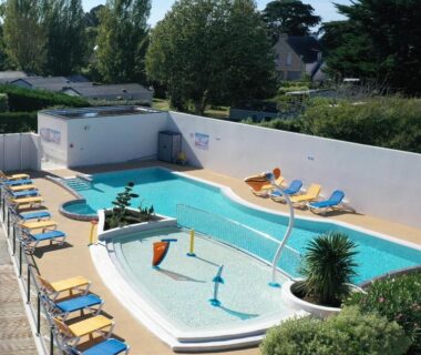 Piscine extérieure avec bassins et transats dans le camping Le Goh Velin