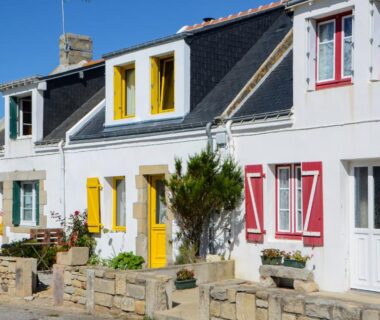 Façades de maisons aux volets colorés dans le camping Le Goh Velin