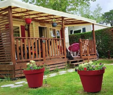 Mobil-home avec terrasse en bois sur pelouse au camping Le HAVRE DU MEN DU