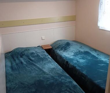 Chambre avec deux lits simples et fenêtre au camping Le HAVRE DU MEN DU